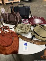 First photo showing seven assorted bags including leather handbag, briefcase, satchel, shoulder bags, crossbody, and purse with strap on white round table.