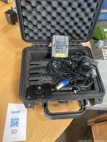 Open hard case showing foam interior with receiver, bodypack transmitters, cables and mic clip