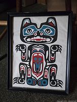 Framed print showing the full image of the Haida-style bear design with bold black, red, and blue colors.