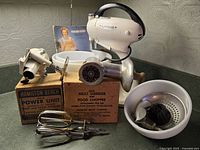 Vintage Hamilton Beach mixer with juicer, meat grinder attachments, original bowls, user manual, and original packaging visible