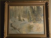 Framed oil painting of snow-covered forest and reflective stream, signed Pickering.