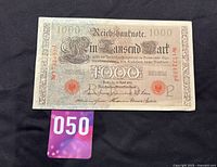 Front side of 1910 German Empire 1000 Mark Reichsbank banknote with serial number 1323195J photographed on black background.