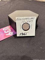 Front side of 1941 Newfoundland 10 Cents silver coin mounted on a black holder with handwritten label.
