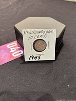 Photo of the coin in a white protective holder labeled 'NEWFOUNDLAND 10 CENTS 1945'.