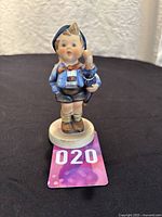 Front view of the porcelain Hummel figurine showing the boy holding the umbrella.