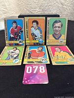Photo of six 1972-73 OPC hockey cards in a set showing six players from different NHL teams with colorful borders and player portraits.