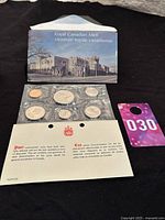 1976 Canadian Proof-Like Coin Set showing six coins sealed in plastic, certificate of authenticity partially unfolded, and original Royal Canadian Mint envelope.