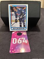 Image of the O-Pee-Chee 1990-91 hockey card showing Guy Lafleur in his Quebec Nordiques uniform, card displayed upright on black surface.