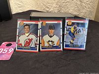 Three 1990-91 Score rookie hockey cards: Martin Brodeur (New Jersey Devils), Jaromir Jagr (Pittsburgh Penguins), Mats Sundin (Quebec Nordiques) in protective sleeves on a black surface.