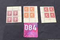 Top down view of three mint plate blocks of King George VI Canadian stamps in denominations 3c, 2c, and 4c arranged on black background.