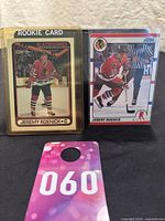Two Jeremy Roenick rookie cards displayed side by side. Left is the O-Pee-Chee card in protective case, right is the Score bilingual card without a case.