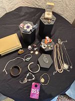 Overall view of assorted jewelry and trinkets on black cloth