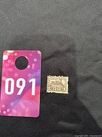 Stamp with purple bidding tag next to it for scale.