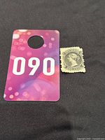 Photo showing the stamp next to a card with the number 090 for scale reference.