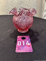 Front side view of the cranberry dusty rose glass candy dish or vase with diamond cut pattern and ruffled edge on black background with lot number 014 visible.