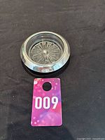 Photo showing the Frank Whiting sterling silver coaster with cut glass insert next to a ticket for scale.