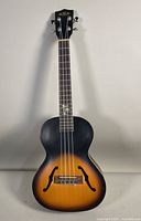 Full front view of the ukulele showing archtop body, f-holes, and tobacco burst finish