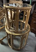 Image showing stacked bamboo frames of the tables without glass tops, highlighting the rattan construction and design details.