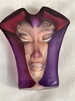 Front view of the Morgana crystal sculpture showing the painted abstract face with purple and red hues and detailed facial features.