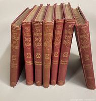 Seven volumes of The World's Best Music set with red hardcovers and gold embossed titles on spines. Books titled Pianoforte Compositions volumes 1-5 and The Great Composers Parts One and Two.