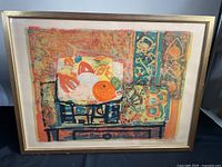 Full view of the framed lithograph artwork by Paul Aizpiri showing warm tones and ornamental designs, with frame and matting visible.