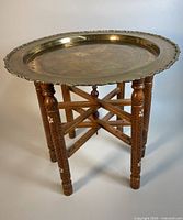 Front view of the folding wood stand with mother-of-pearl inlay and brass serving tray on top
