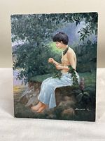 Full frontal view of the signed oil painting featuring the nude woman sitting outdoors against a natural background with foliage. Visible wear on edges and bottom.