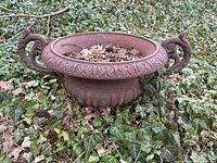 Front view of cast iron urn planter showing overall shape, handles and surface condition