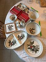 Full view of all table items including divided serving bowl, bowls, jug, vase, salt and pepper shakers, pastry forks and teaspoons in cases, and a cork trivet tile with holly decoration.