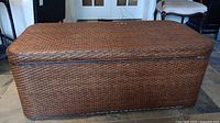 Front and top view of large wicker-look storage chest, showing rectangular shape and pattern detail.