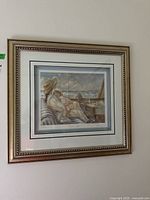 Full framed art print hanging on wall depicting the "Little Sailor" artwork by Trisha Romance, showing a woman with a child on a boat and sailboats in the background.