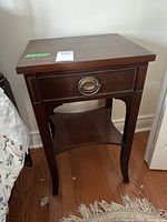 Front view of the vintage wooden side table showing drawer and leg design.