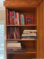 Bookshelf with multiple cookbooks including Williams Sonoma series, grilling, Paris cuisine, and Pizza Night.