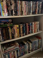 Shelves with DVDs and VHS tapes showing various movie titles and cover arts.