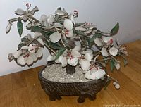 Front and side views of the glass bonsai tree showing white glass flowers with red accents, green leaves, textured trunk, and brown ceramic pot with white pebbles.