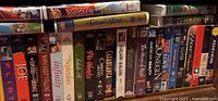 Photo of VHS tapes on a shelf showing titles and spines with various movies