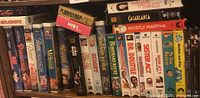 Photo showing a collection of VHS and DVD movie cases including classics like Casablanca, Sister Act, and animated titles.