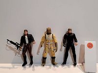 Photo showing three Star Wars figures Han Solo, Bossk, and Luke Skywalker standing upright with good detail visible in their costumes and accessories.