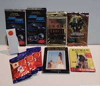 Photo showing a variety of unopened trading card packs including Star Trek The Next Generation, Marvel Masterpieces, Smalls Soldiers, McDonald's promotional cards, Space Shuttle, and Batman Returns.