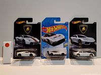 Photo showing three Hot Wheels cars in original packaging, all Lamborghini models with white and silver paint.
