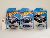 Photo showing three Hot Wheels collectible cars in original packaging: Custom '12 Acura NSX, '14 Audi S5 Cabriolet, and Chevy SS.