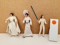 Three Star Wars action figures consisting of two princess Leia and one Luke Skywalker figures displayed against a plain backdrop with lot number 33 card to the right.