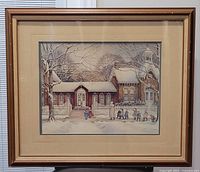 Photo of framed print showing a snowy winter scene with children walking by a house framed in medium brown wood.