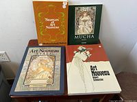Front view of four vintage Art Nouveau books showing illustrated covers.