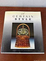 Front cover of the book showing title and image of a brown plastic handbag with a decorative handle.