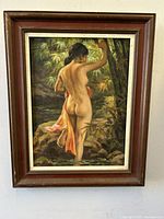 Full view of the framed oil painting depicting a nude woman standing in water in a forested setting.