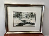 Framed watercolor painting showing abstract river and trees with signature and date visible.