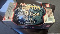 View showing the football in original box with labels visible including Wilson brand and Toronto Argonauts logo and measurement details.