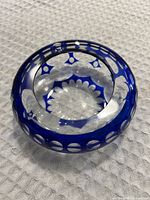 Angled side view showing cobalt blue coloring and cut glass crystal detail of ashtray.