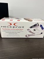Original box showing product name 'NeckPro II' and description of device as an over-the-door cervical traction device to relieve neck pain.